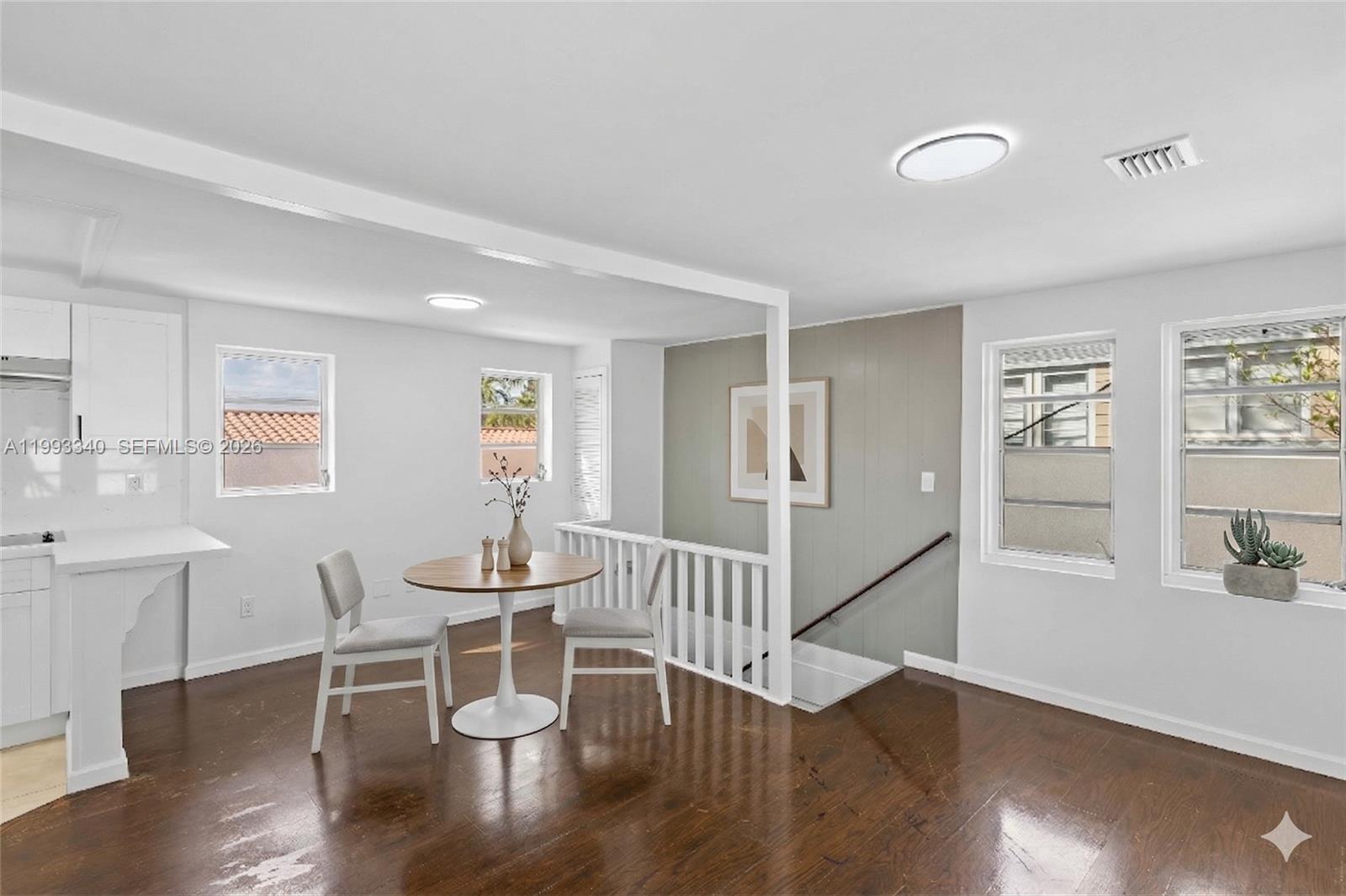 1408 Southwest 19th Terrace, Unit 1406 Miami, FL 33145 - Photo 2 of 12 a dining room with wooden floor and white walls