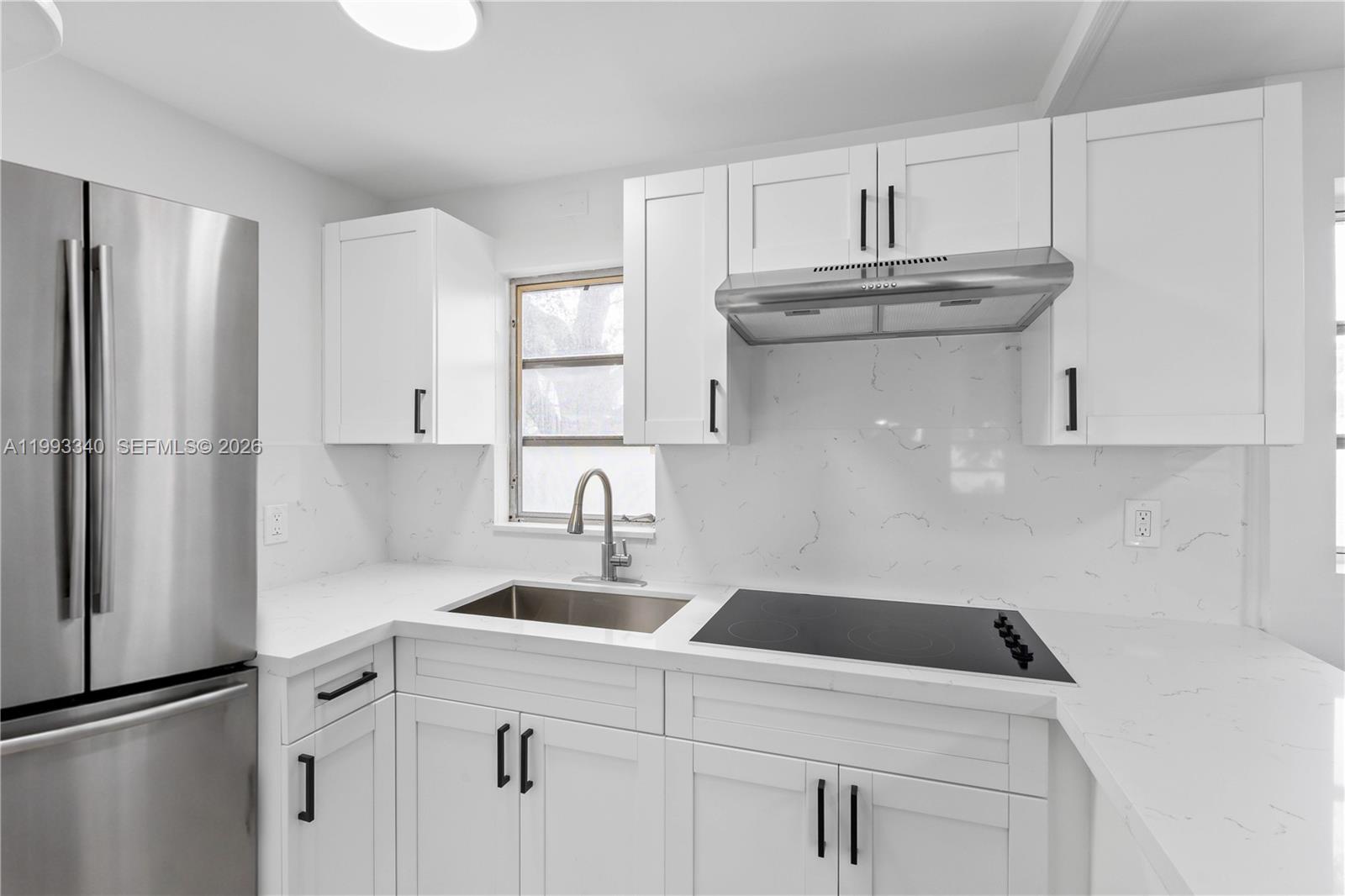 1408 Southwest 19th Terrace, Unit 1406 Miami, FL 33145 - Photo 6 of 12 a kitchen with stainless steel appliances granite countertop a sink stove and refrigerator