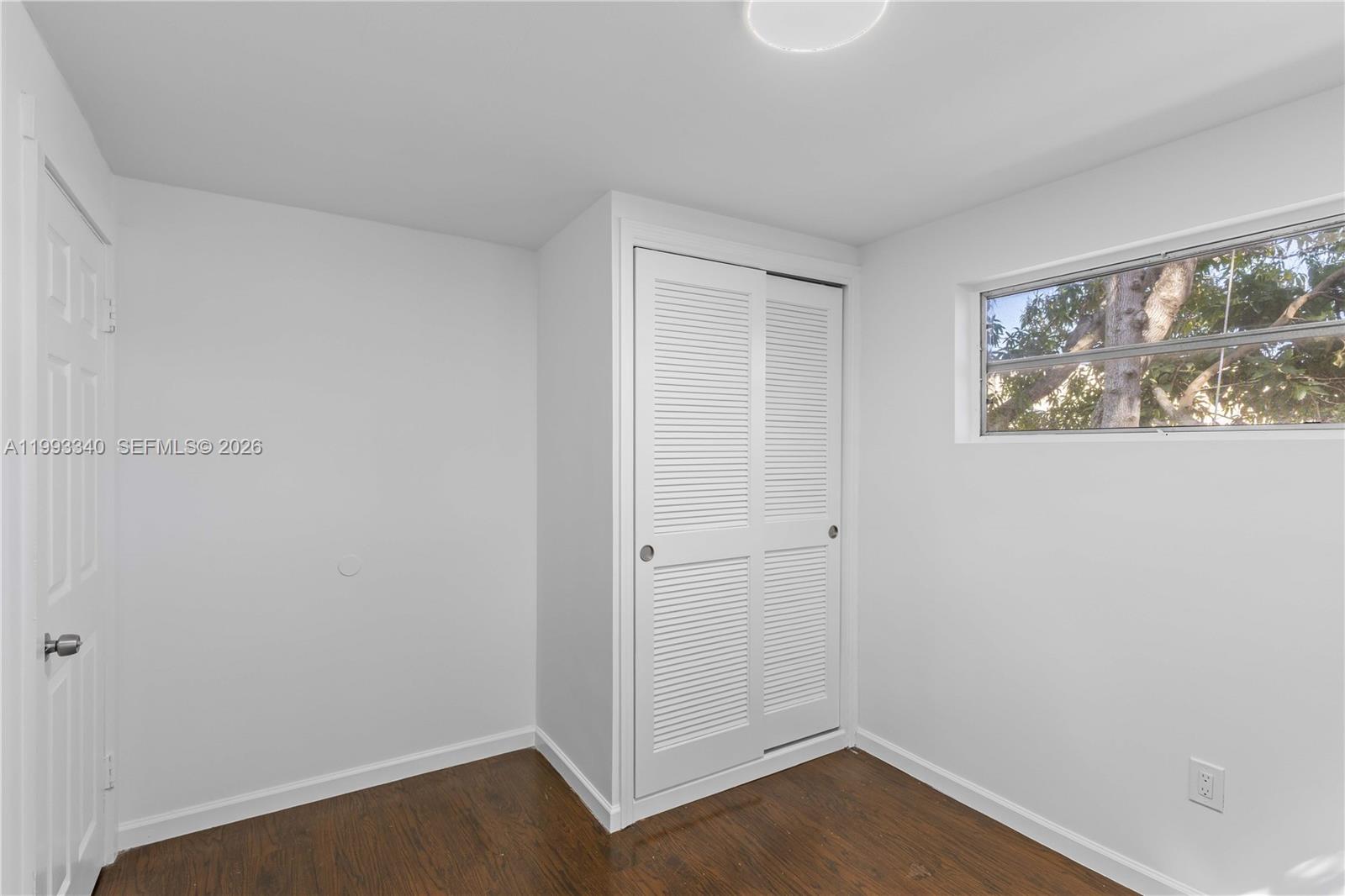 1408 Southwest 19th Terrace, Unit 1406 Miami, FL 33145 - Photo 7 of 12 an empty room with wooden floor and windows