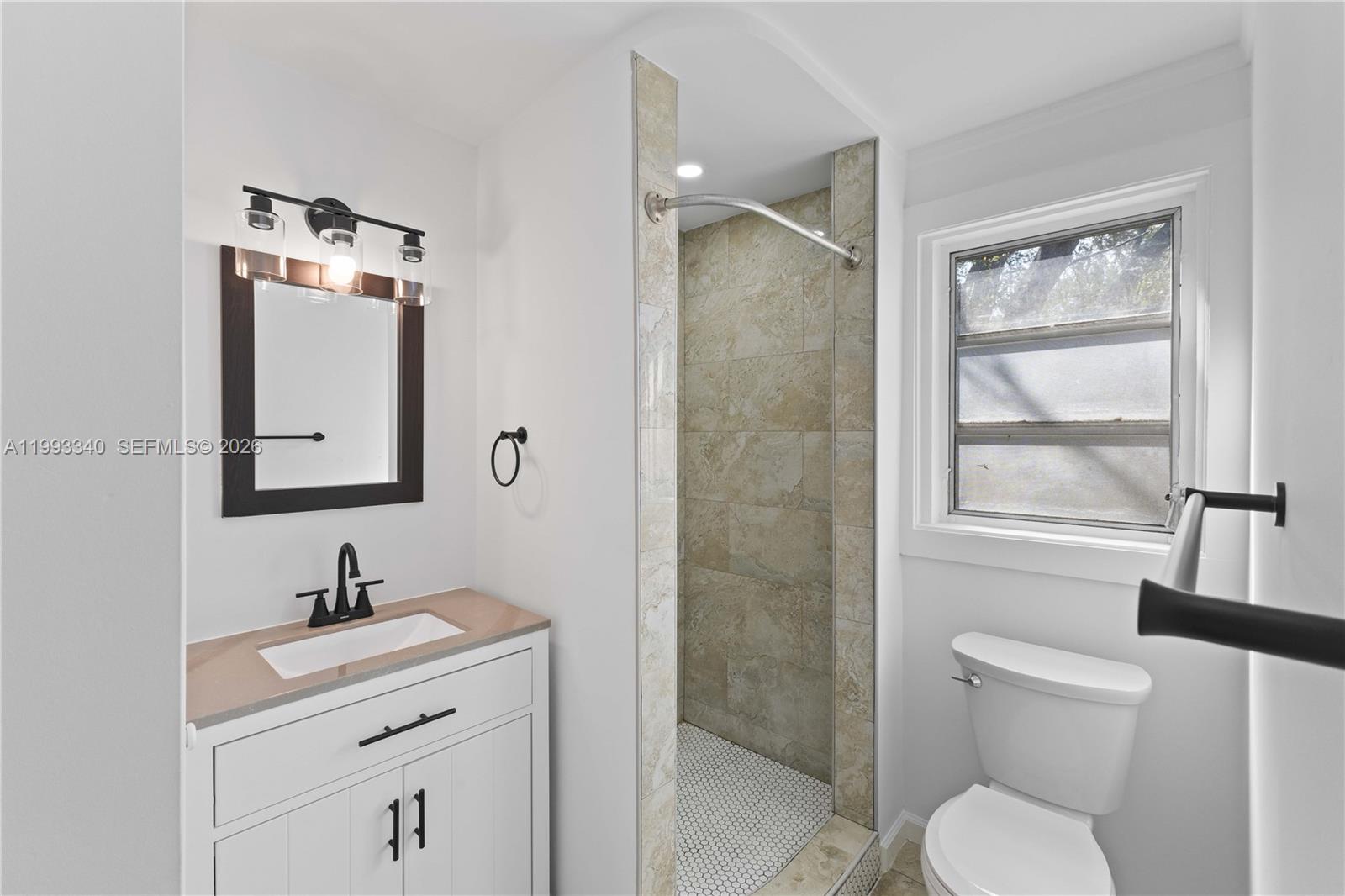 1408 Southwest 19th Terrace, Unit 1406 Miami, FL 33145 - Photo 9 of 12 a bathroom with a toilet sink a mirror and shower