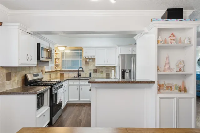 a kitchen with stainless steel appliances granite countertop a stove a sink and a refrigerator