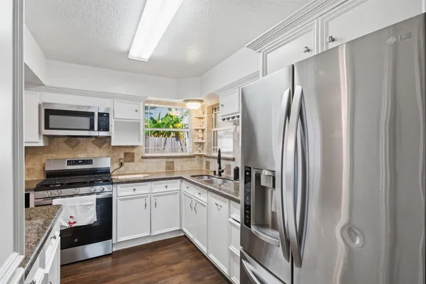 a kitchen with stainless steel appliances a refrigerator sink and microwave
