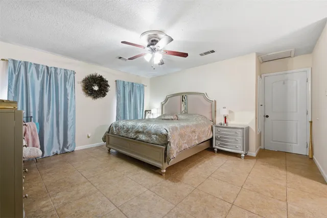 a spacious bedroom with a bed and a chandelier