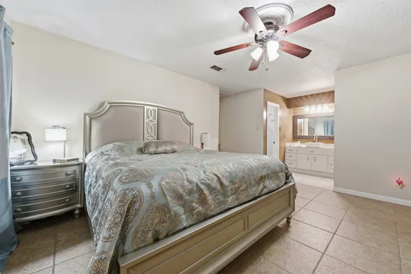 a spacious bedroom with a bed and a chandelier