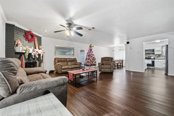 a living room with furniture a fireplace and wooden floor