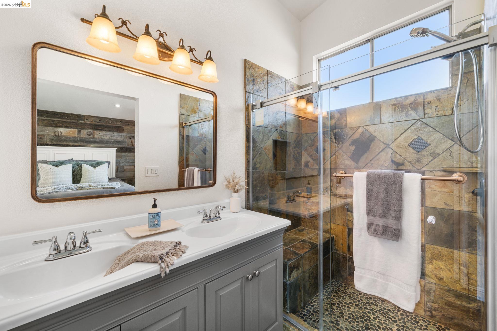 1186 El Rio Court Livermore, CA 94551 - Photo 20 of 60 Dual vanity with undermount sinks, a framed mirror, and a five-light fixture