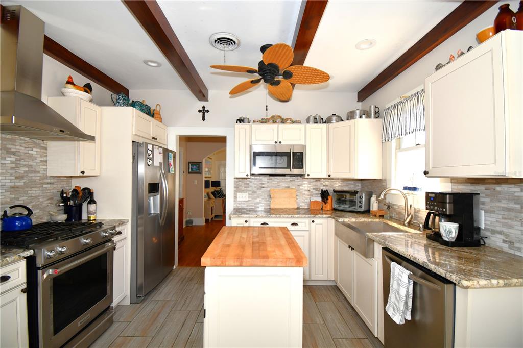 1245 Alexander Street Mount Dora, FL 32757 - Photo 17 of 55 a kitchen with stainless steel appliances granite countertop a sink a stove and refrigerator