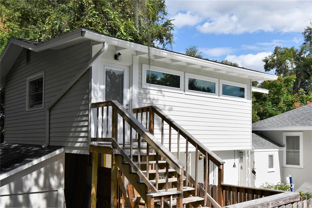 1245 Alexander Street Mount Dora, FL 32757 - Photo 36 of 55 a view of a house with wooden stairs and a large tree