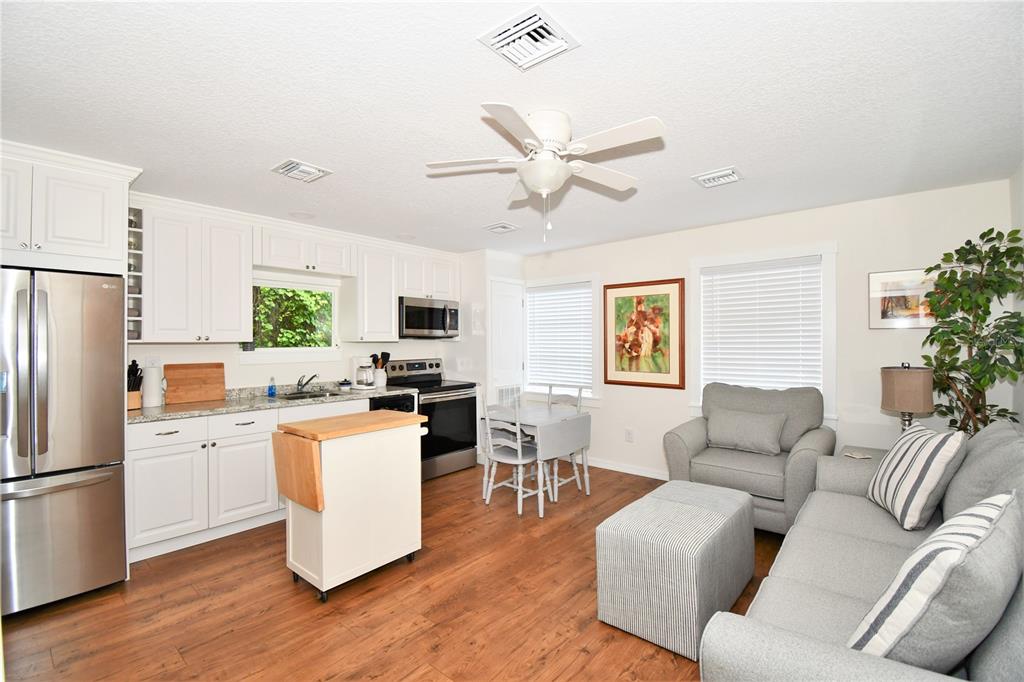 1245 Alexander Street Mount Dora, FL 32757 - Photo 39 of 55 a living room with furniture a refrigerator and a dining table with wooden floor