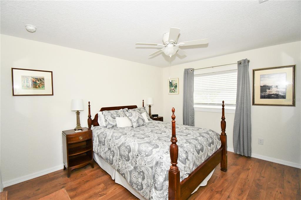 1245 Alexander Street Mount Dora, FL 32757 - Photo 43 of 55 a bedroom with a large bed and a chandelier