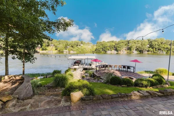 a large dining hall with stainless steel appliances granite countertop a stove kitchen island a table and chairs in it