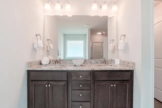 a bedroom with a bed a mirror and a large window