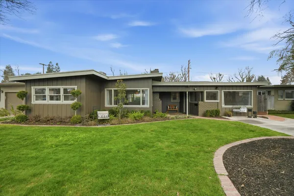 a view of a house with a yard and sitting area