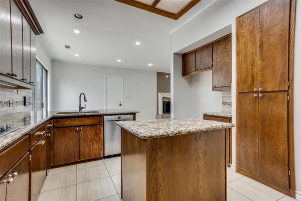 a kitchen with stainless steel appliances granite countertop a sink refrigerator and cabinets
