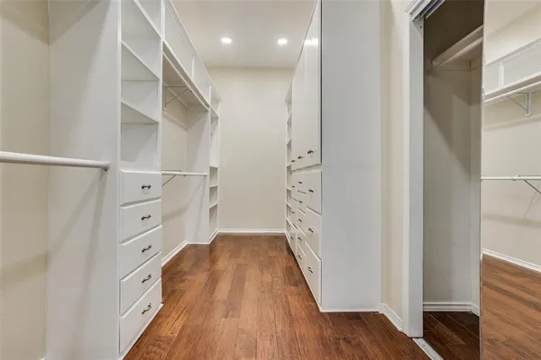 a view of walk in closet with wooden floor