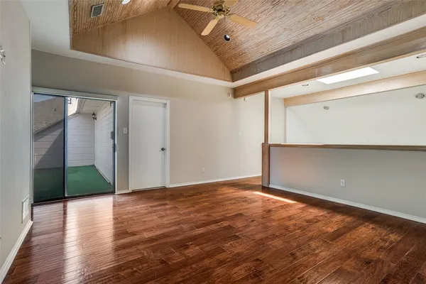 a view of an empty room with wooden floor