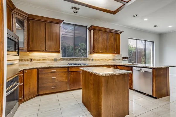 a kitchen with stainless steel appliances granite countertop a stove a sink and a microwave