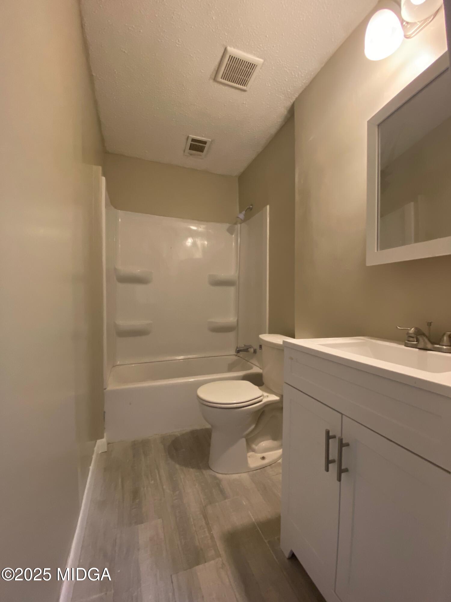 117 Laura Lane Fort Valley, GA 31030 - Photo 19 of 31 a bathroom with a granite countertop sink toilet a mirror and shower