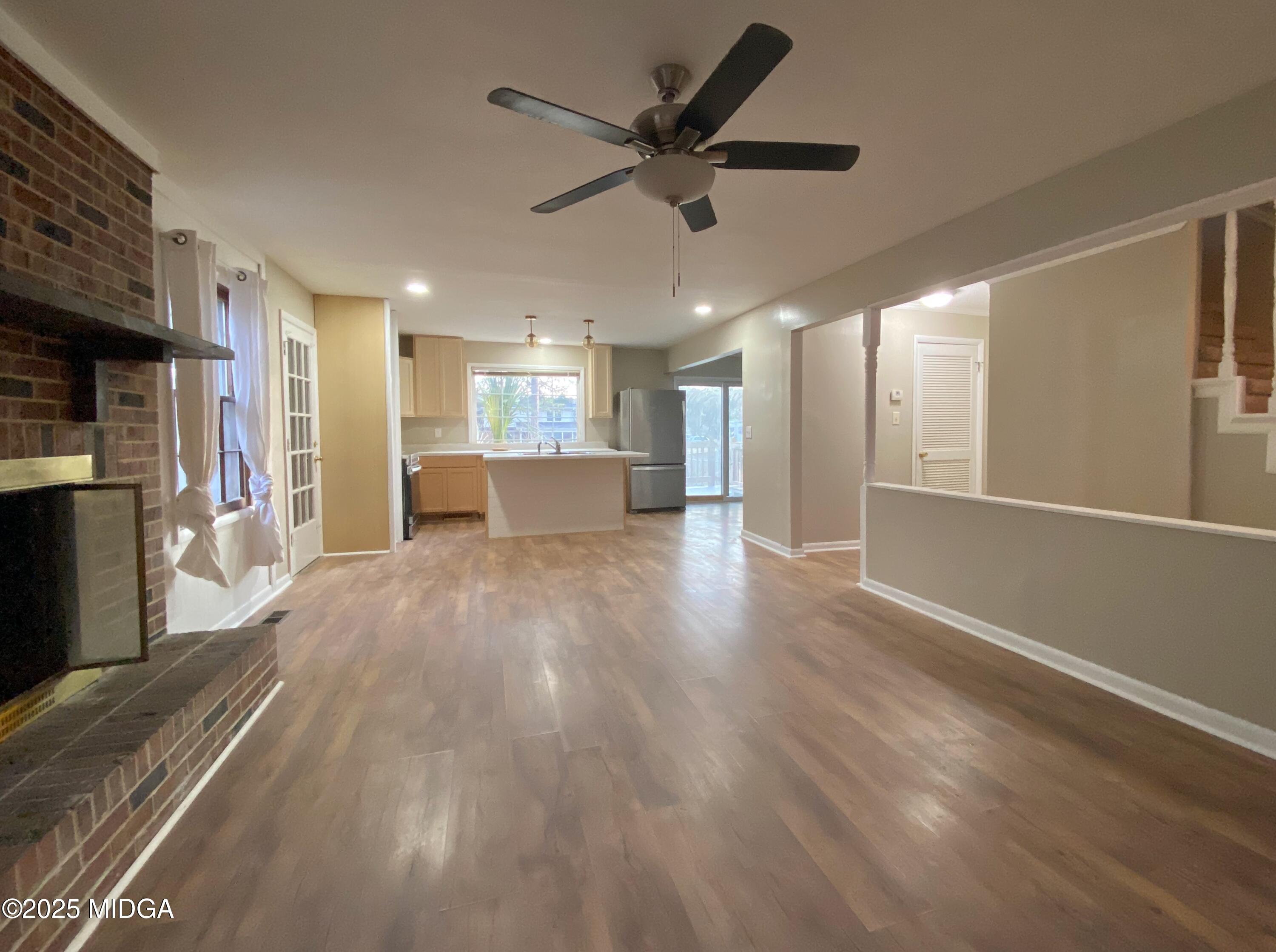 117 Laura Lane Fort Valley, GA 31030 - Photo 3 of 31 a view of a big room with wooden floor a ceiling fan and windows