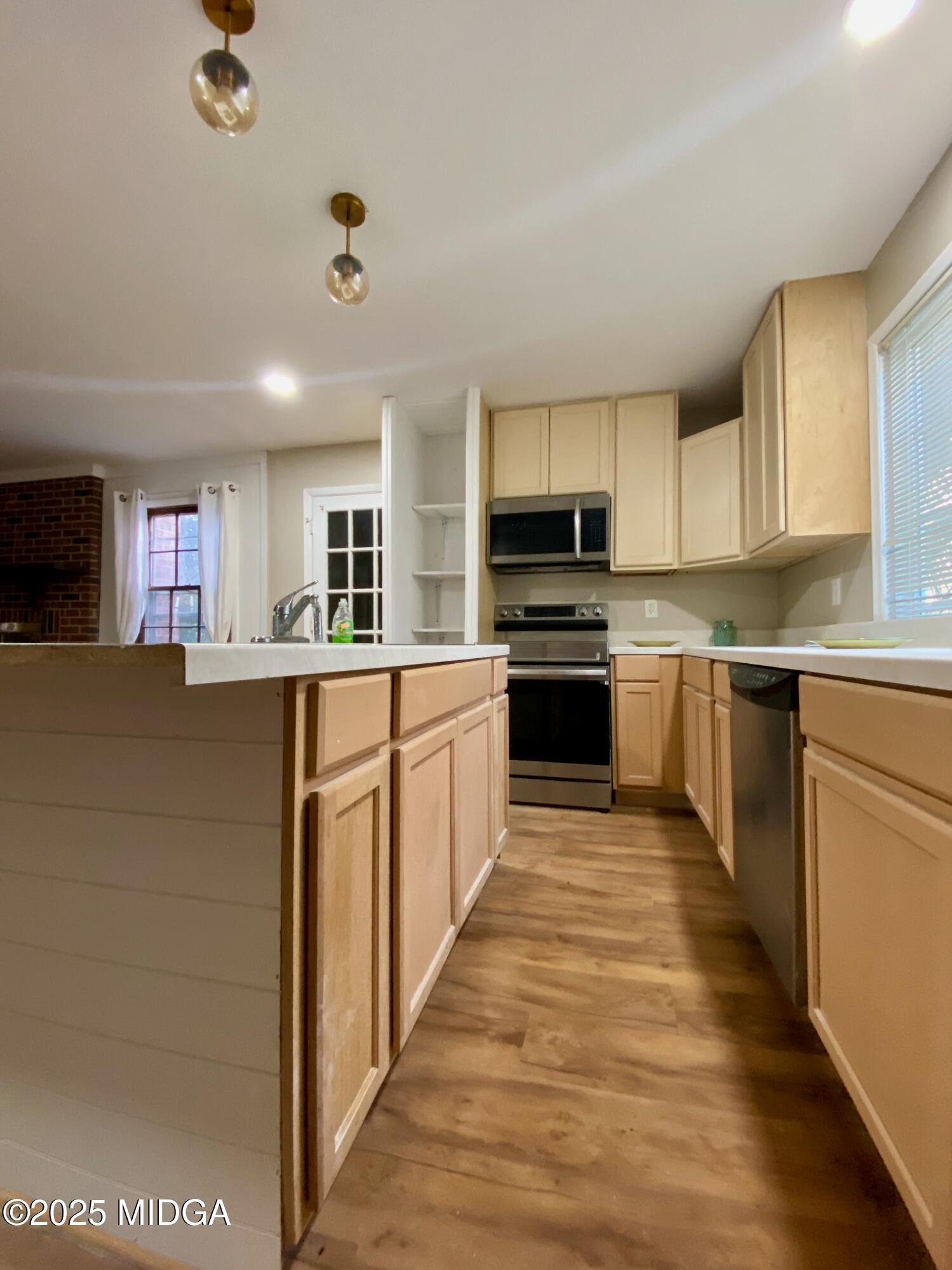 117 Laura Lane Fort Valley, GA 31030 - Photo 6 of 31 a large kitchen with stainless steel appliances granite countertop a stove top oven a sink dishwasher and a refrigerator with wooden floor