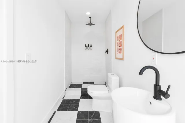 a bathroom with a sink a toilet and shower