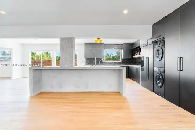 a kitchen with stainless steel appliances a refrigerator sink and wooden cabinets