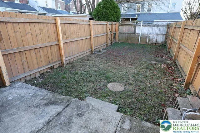 a view of a backyard with wooden fence
