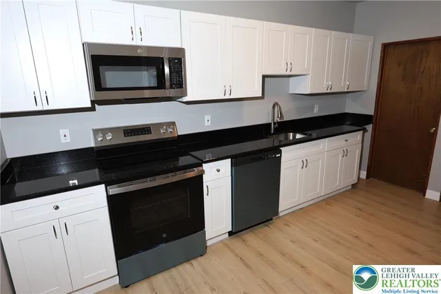 a kitchen with granite countertop a stove and a microwave