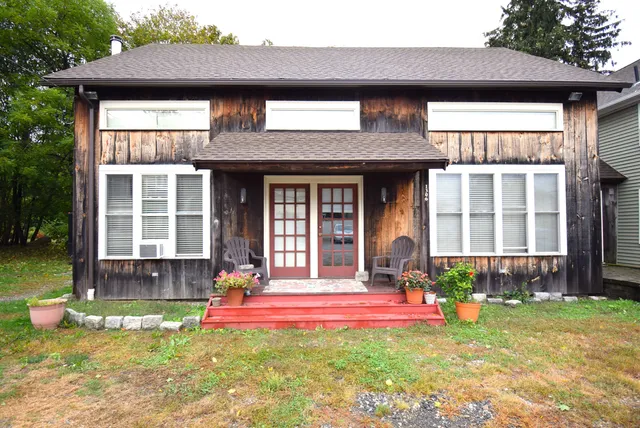 a view of a house with a yard and sitting area
