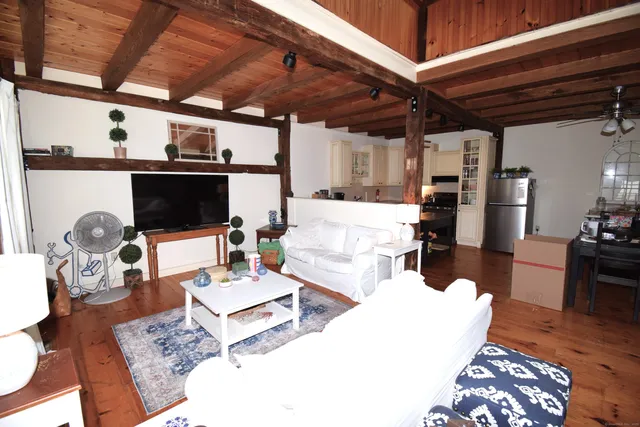 a living room with furniture appliances and wooden floor