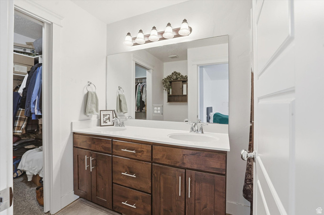 1024 South 270 West Logan, UT 84321 - Photo 17 of 37 Bathroom with double vanity, a spacious closet, and ensuite bath