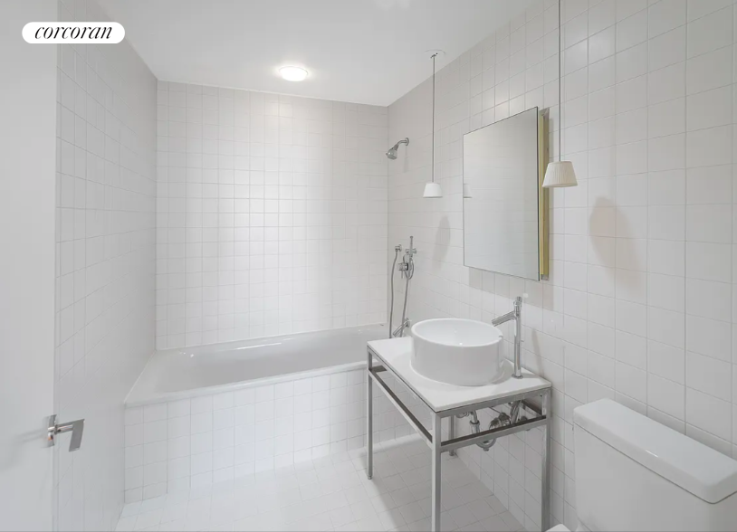 15 Broad Street, Unit 1610 Manhattan, NY 10005 - Photo 8 of 8 a bathroom with a sink toilet vanity and tub