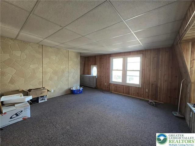 a view of a livingroom with gym equipment and a window