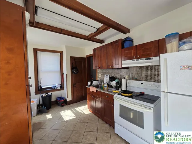 a kitchen with a stove a refrigerator and cabinets