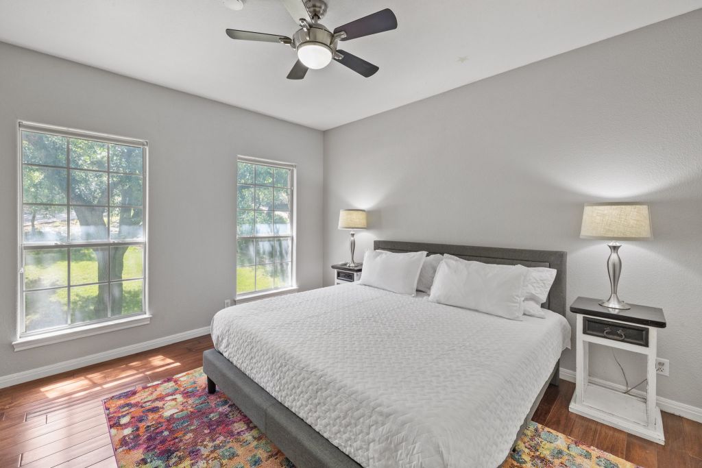 10800 Beach Road Leander, TX 78641 - Photo 20 of 39 A well-lit bedroom featuring rich hardwood flooring and a functional ceiling fan for optimal comfort.