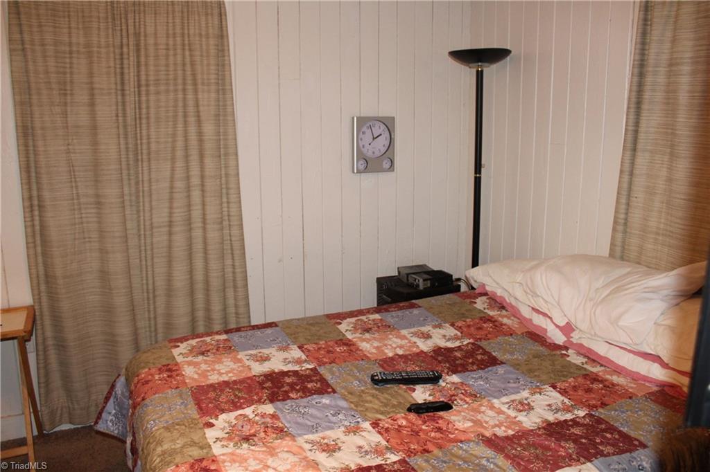 4758 Kinnamon Road Clemmons, NC 27012 - Photo 14 of 30 2nd bedroom has solid wood paneling and beige carpet in good shape