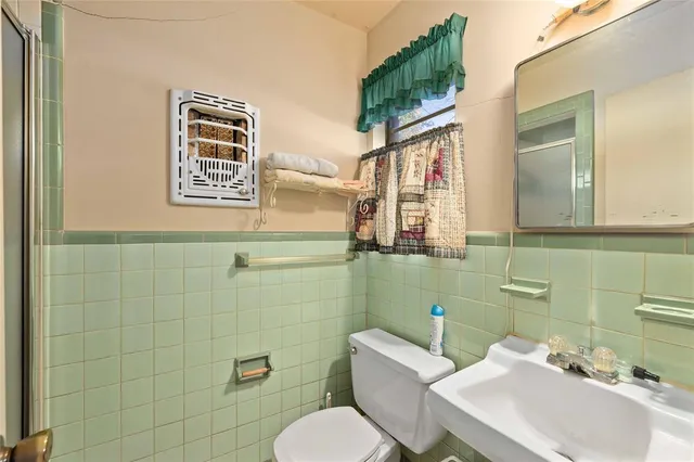 a bathroom with a sink mirror and toilet