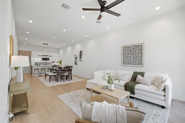 a living room with furniture and a view of kitchen