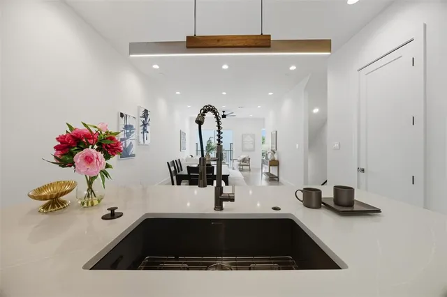 a kitchen with a sink a refrigerator and chairs