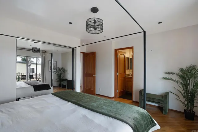 a bedroom with a bed and a large mirror with a potted plant