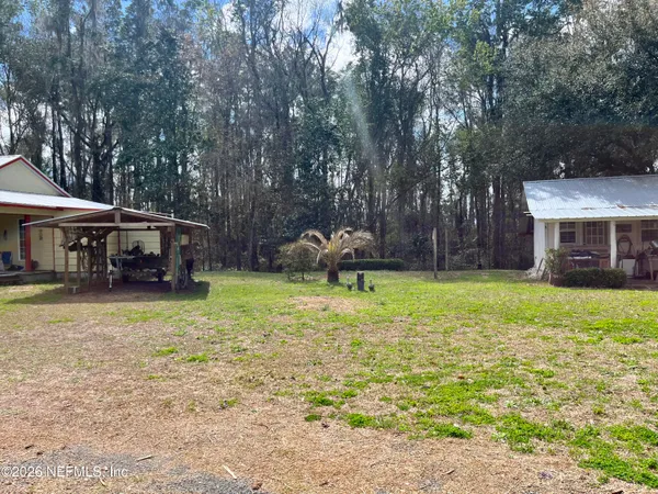 a backyard of a house with yard table and chairs