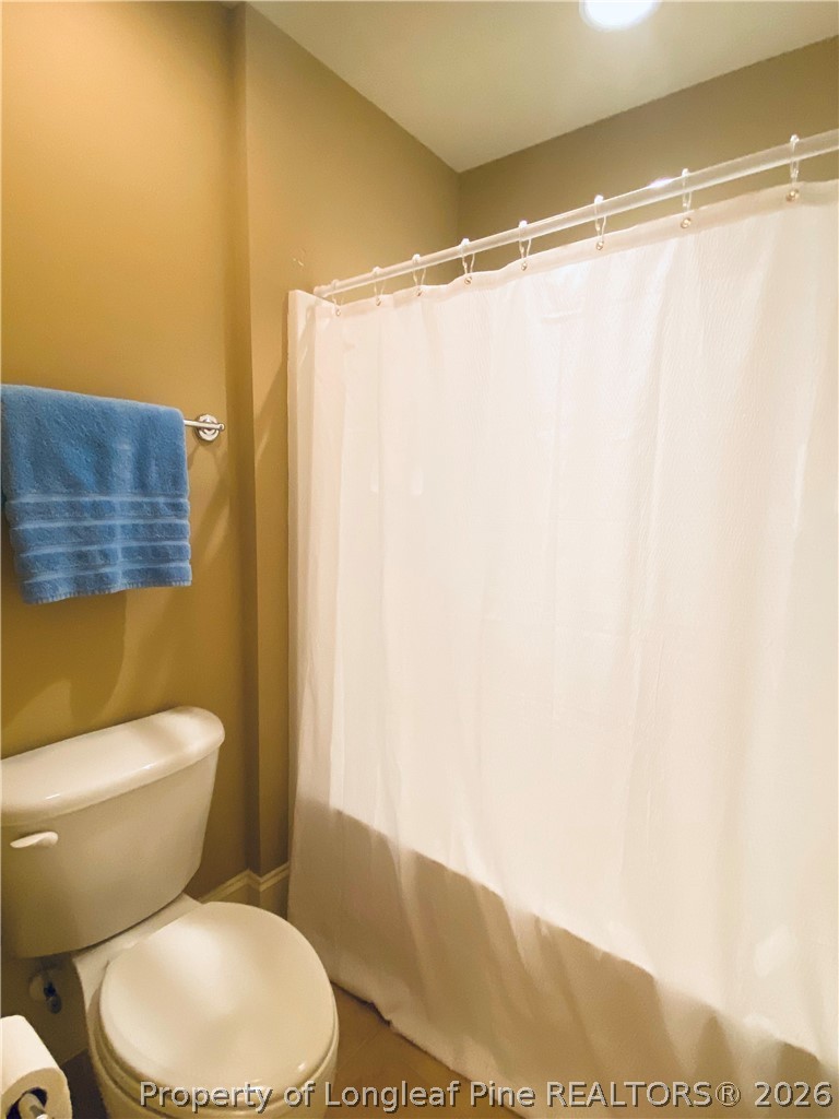 175 Pine Hawk Drive Spring Lake, NC 28390 - Photo 34 of 43 a white toilet sitting next to a shower curtain