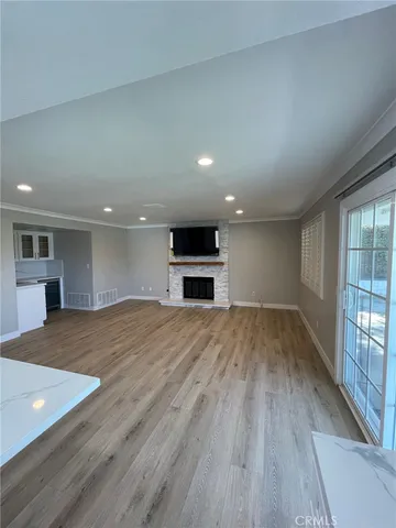 wooden floor in an empty room with a kitchen