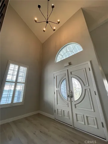 an entryway with wooden floor cabinet and door