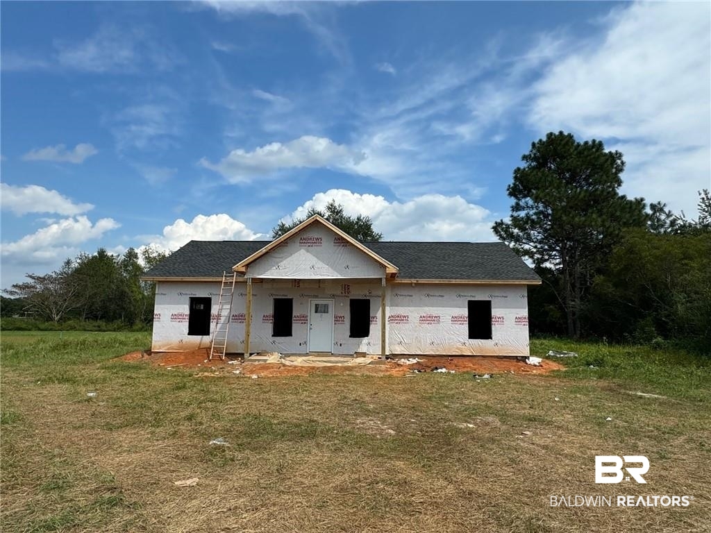 Property in mid-construction with a front lawn and covered porch