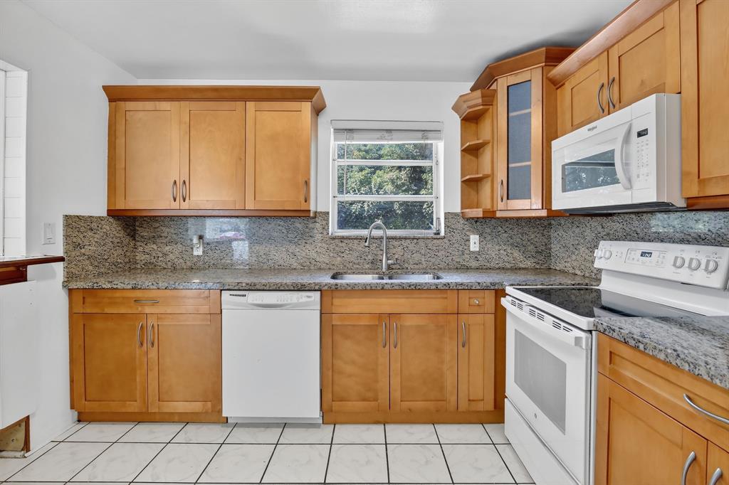 4631 Southwest 54th Terrace Davie, FL 33314 - Photo 15 of 42 a kitchen with stainless steel appliances granite countertop a stove sink and cabinets