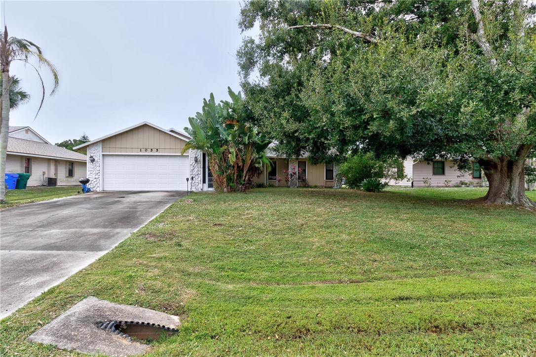 1055 Barber Street Sebastian, FL 32958 - Photo 3 of 18 a front view of a house with a garden and trees