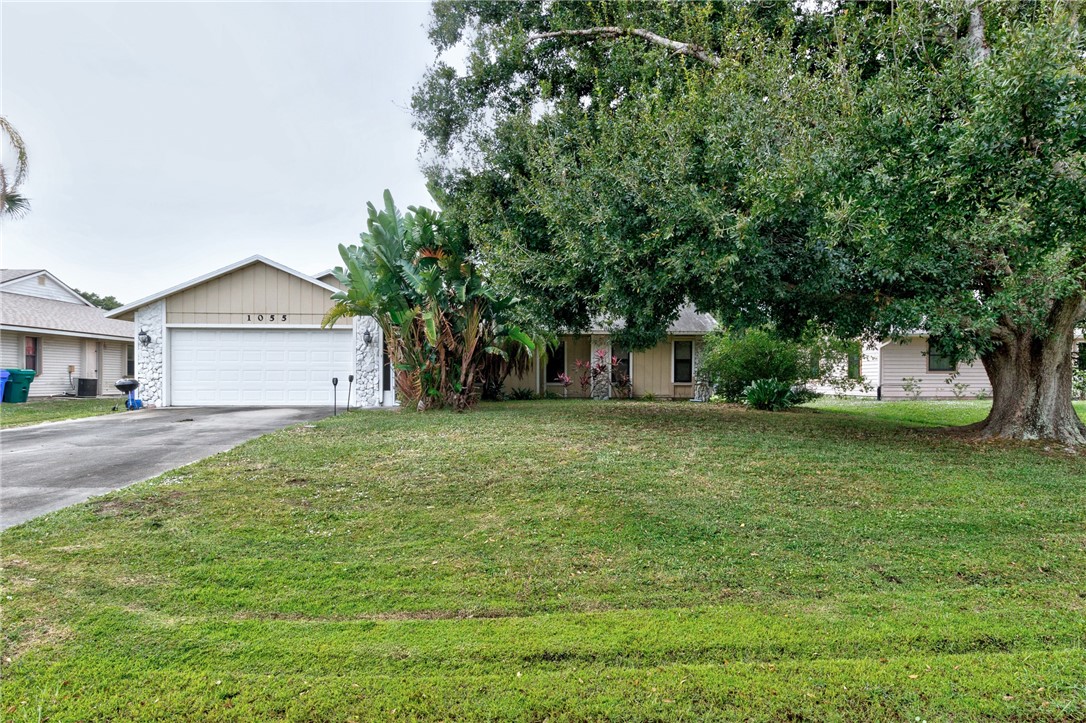 1055 Barber Street Sebastian, FL 32958 - Photo 8 of 18 a front view of a house with a garden and trees