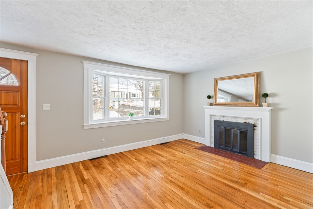 9 Pearl Street Walpole, MA 02081 - Photo 5 of 22 a view of empty room with fireplace and wooden floor