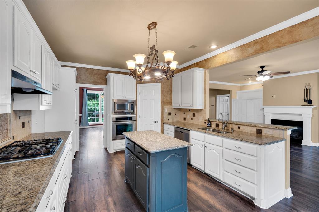 1907 Timber Ridge Court Cedar Hill, TX 75104 - Photo 6 of 30 Kitchen featuring a central island, wood-finish flooring, white cabinetry, and granite countertops